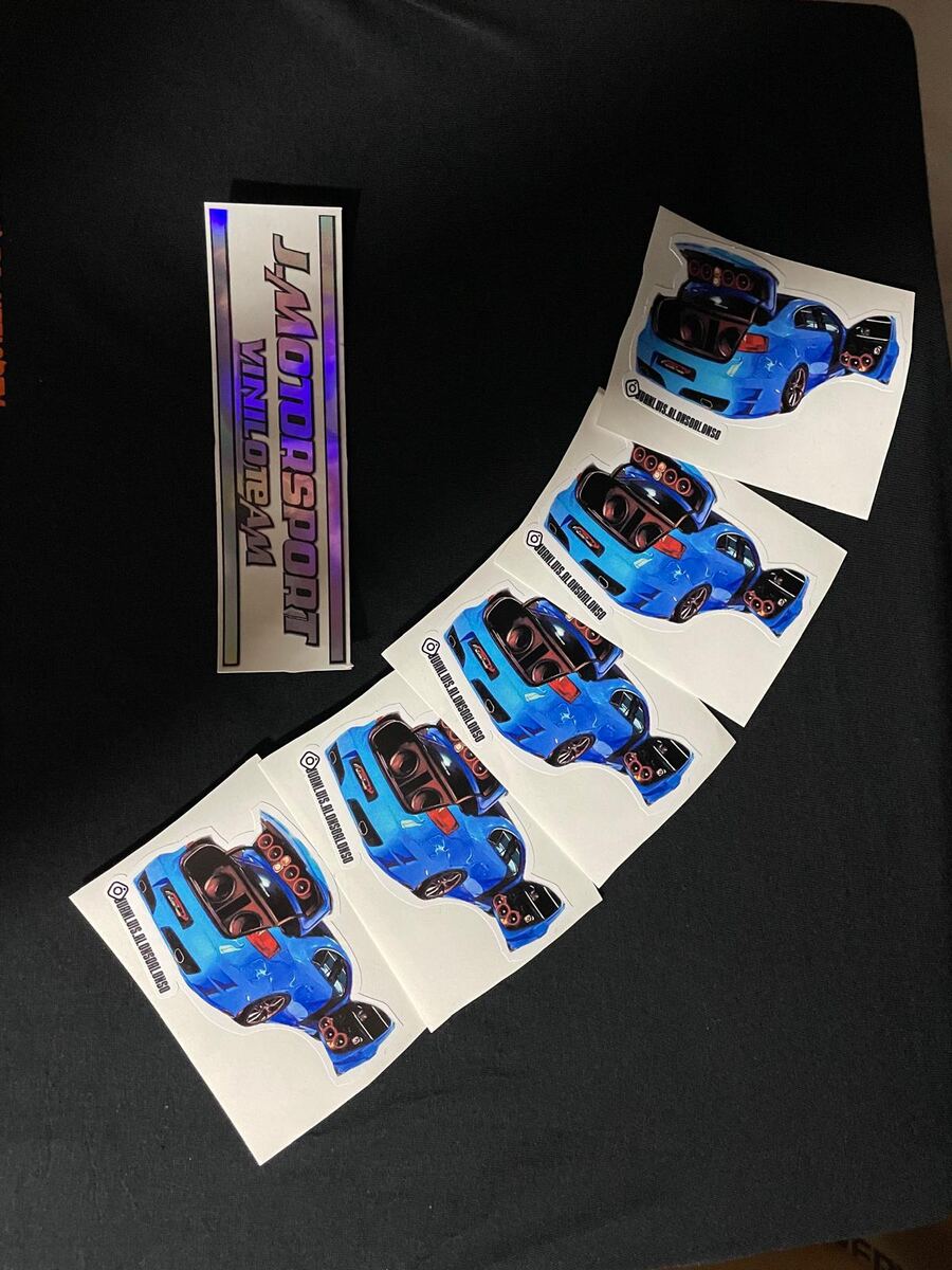 Pegatinas personalizadas con el coche de un cliente y pegatina holográfica de JMotorsport, recién cortadas en el taller
