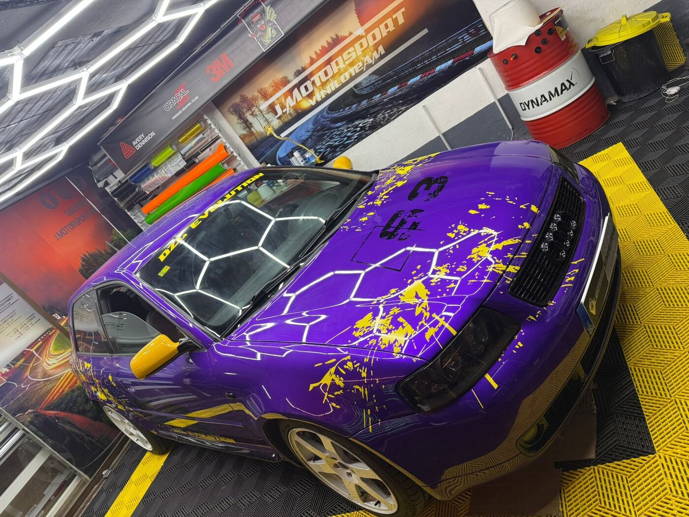Coche vinilado en morado con salpicaduras amarillas dentro del taller de Illescas